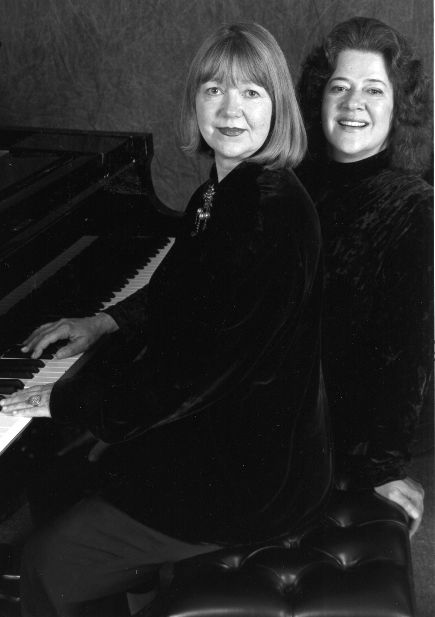 Black and white photo of Inara Morgenstern and Victoria Neve seated at a piano